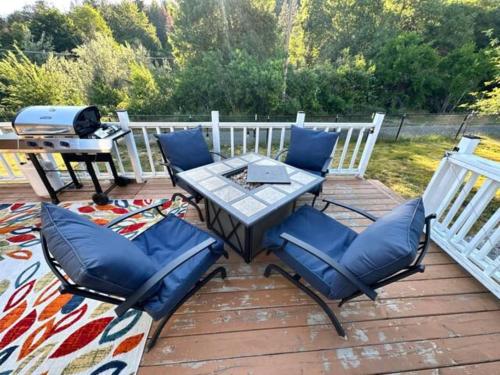 a patio with a table and chairs and a grill at Enchanting Getaway Farmhouse And Tiny House Duo in Jacksonville