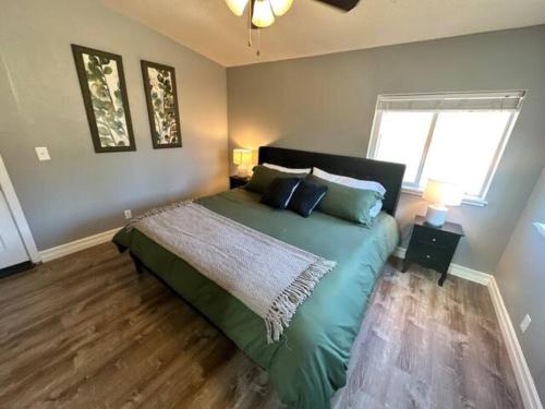 a bedroom with a green bed in a room at Enchanting Getaway Farmhouse And Tiny House Duo in Jacksonville