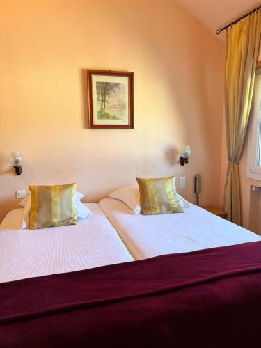 a bedroom with two beds with white sheets and a window at Hôtel l'Orée des Roches in Saales