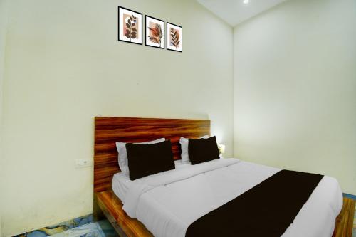a bedroom with a large bed with a wooden headboard at Hotel O The Suresh Mahal Resort in Jaipur