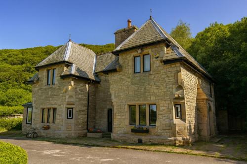 an old stone house sitting on the side of a road at 4 Bed Retreat-Sleeps 7-Parking-Garden-Lake Views in Bolton