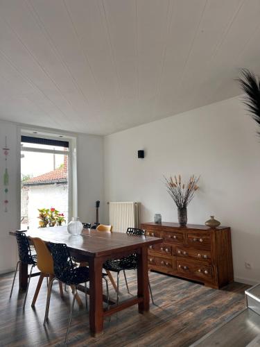 a dining room with a wooden table and chairs at La maison heuvelland in Heuvelland