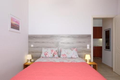 a bedroom with a pink bed with two pink pillows at Kiveri Gems Houses in Kivérion