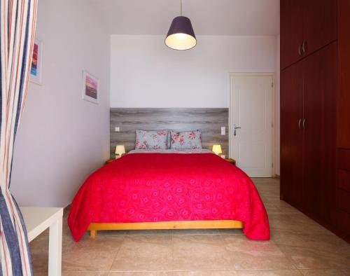 a bedroom with a red bed with a red blanket at Kiveri Gems Houses in Kivérion