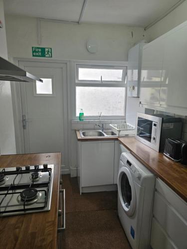 a kitchen with a washing machine and a microwave at Salus Bed 1 Liverpool City in Liverpool