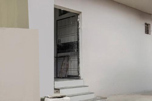 a door in a white building with stairs at Hotel O Sushant Hotels NSEZ Metro Station in Sūrajpur