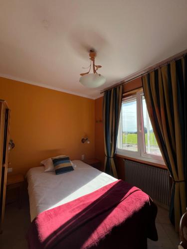a bedroom with a bed and a window at Hôtel l'Orée des Roches in Saales