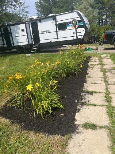 Ein Anhänger steht auf einem Feld mit Blumen in der Unterkunft Cozy camper escape close to boothbay in Edgecomb
