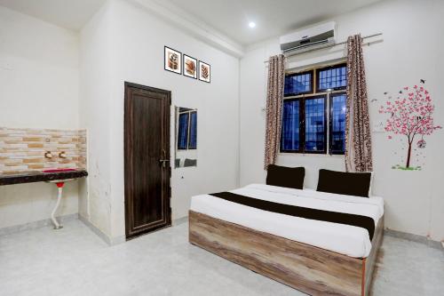 a bedroom with a bed and a window at Hotel O Kashi Home in Kakarmatha