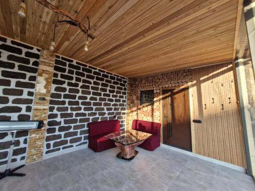 a room with two chairs and a table and a brick wall at Gastro Garden Guesthouse in Aramus