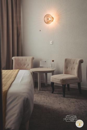 a hotel room with a bed and a table and chairs at Hotel Chantereyne in Cherbourg en Cotentin