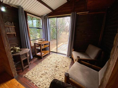 a living room with a couch and a window at Nullarbor Cottages in Magaliesburg