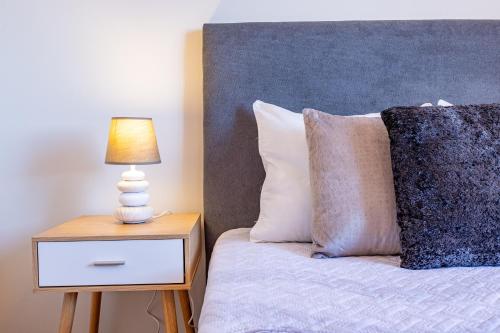 a bed with a side table with a lamp on it at The Nature Nest by YOUR KEY MADEIRA in Santana