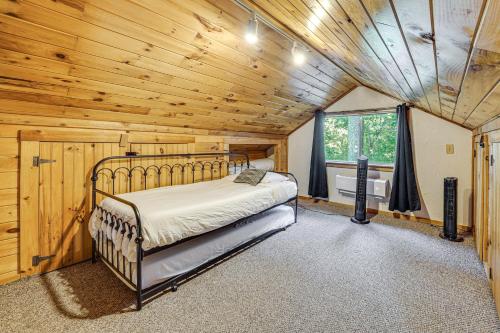 a bedroom with a bed in a room with wooden ceilings at 3 Mi to Beavers Bend State Park Hot Tub Hideaway! in Broken Bow