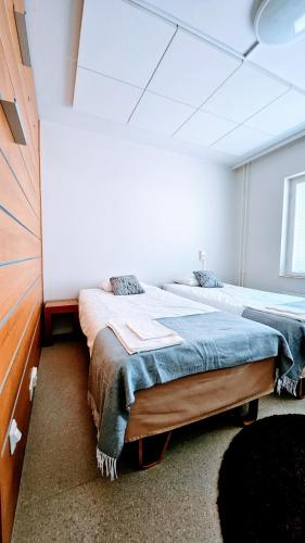 a bedroom with two beds in a room at Hotelli Sammatti in Lohja