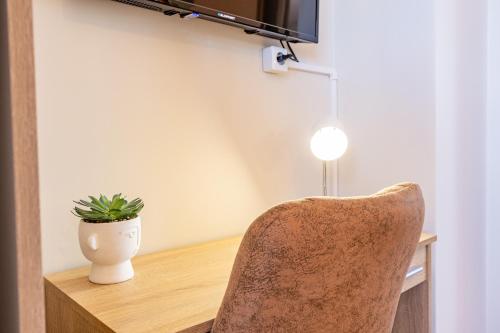 a plant in a vase sitting on a desk with a chair at The Nature Nest by YOUR KEY MADEIRA in Santana