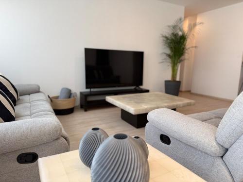 a living room with two couches and a flat screen tv at Exclusive Comfort Apartment in Querétaro