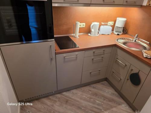 a kitchen with a sink and a counter top at PEMATRA FeWo Nordlicht in Travemünde