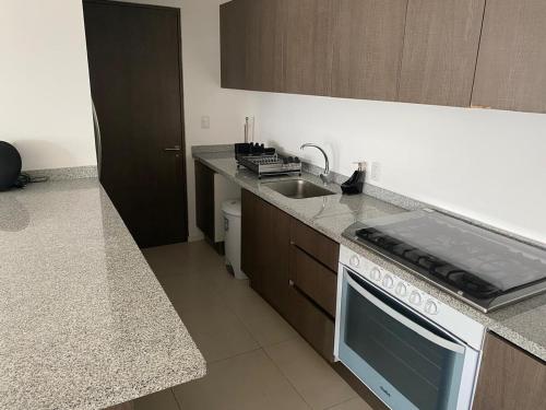 a kitchen with a sink and a stove top oven at Exclusive Comfort Apartment in Querétaro