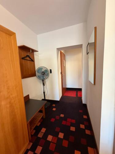 a hallway with a room with a desk and a fan at Altstadthotel Wetzel in Mühldorf