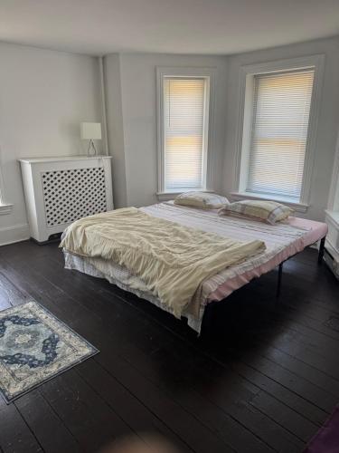a bedroom with a large bed and two windows at - Historic District Haven 3BR, 2BA Townhome Escape 