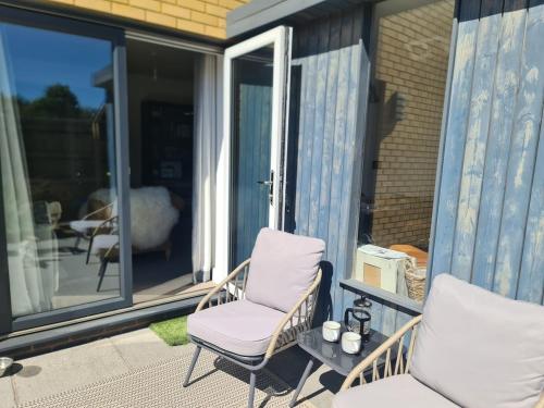 a porch with a chair and a window at The Snuggery-Hot Tub-Parking-Eco in Topsham