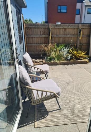 two chairs sitting on a patio next to a building at The Snuggery-Hot Tub-Parking-Eco in Topsham
