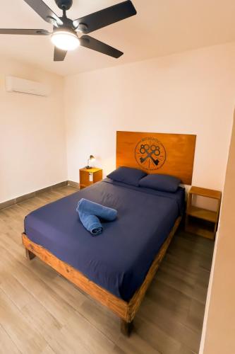 a bedroom with a large bed with blue pillows at Balu Hotel in Isla Mujeres