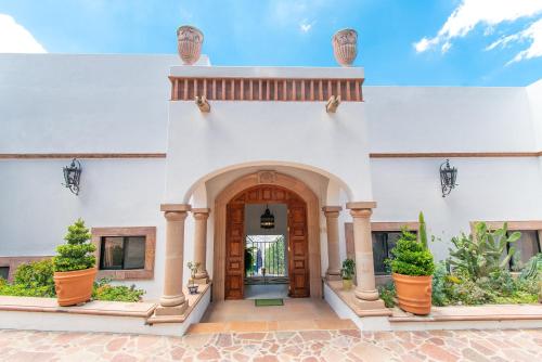 an entry to a building with an archway and potted plants at Casa Estrella de la Valenciana Hotel Boutique in Guanajuato