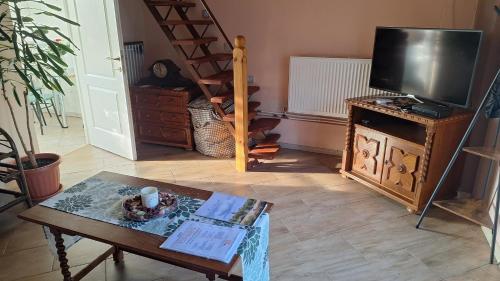 a living room with a tv and a coffee table at Erika Apartman in Szentgyörgyvölgy