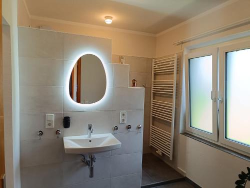 a bathroom with a sink and a mirror at ZeitRaum bei Henne in Wiesmoor
