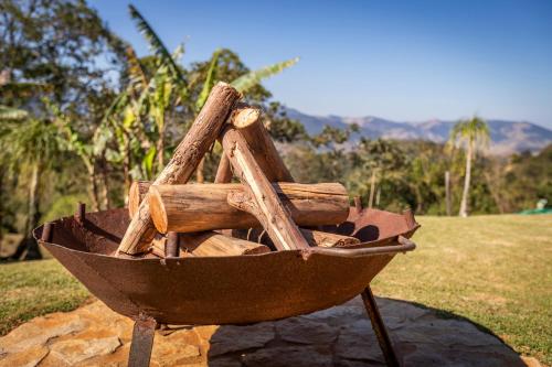 a wheelbarrow filled with logs on top of a field at Chácara da Mantiqueira - São Francisco Xavier in São José dos Campos