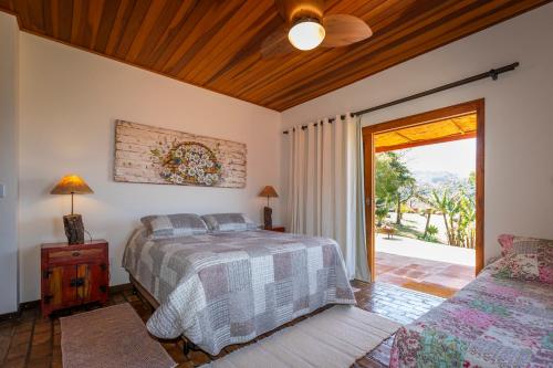a bedroom with a bed and a sliding glass door at Chácara da Mantiqueira - São Francisco Xavier in São José dos Campos