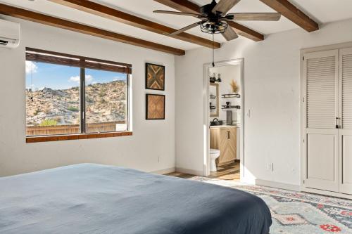 a bedroom with a bed and a ceiling fan at Las Rocas By The Cohost Company in Yucca Valley