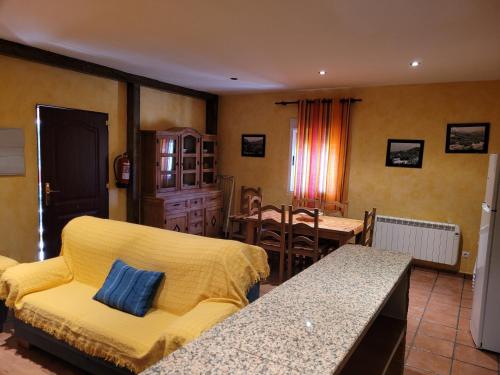 a living room with a yellow couch and a table at Casa Béjar in Quesada