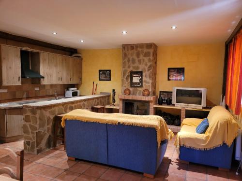 a kitchen with two chairs and a tv in a room at Casa Béjar in Quesada