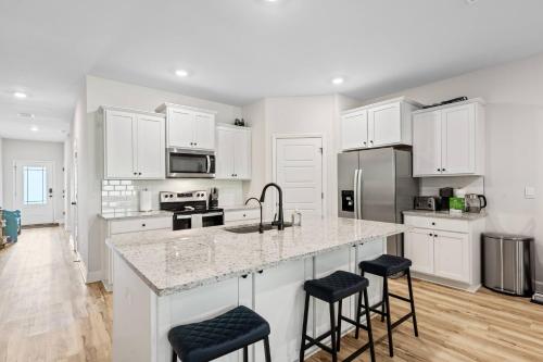 a kitchen with white cabinets and a kitchen island with stools at Spacious 4BR Home Near Midtown & FSU in Saint Peter