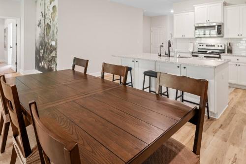 a kitchen with a wooden table and chairs at Spacious 4BR Home Near Midtown & FSU in Saint Peter