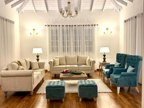 a living room with couches and blue chairs at The Mountain Links, Upcot, Nuwara Eliya in Maskeliya