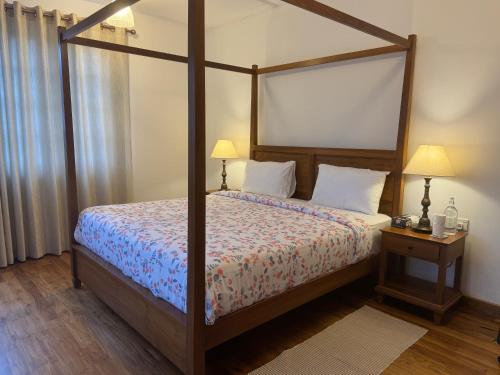 a bedroom with a four poster bed with a canopy at The Mountain Links, Upcot, Nuwara Eliya in Maskeliya