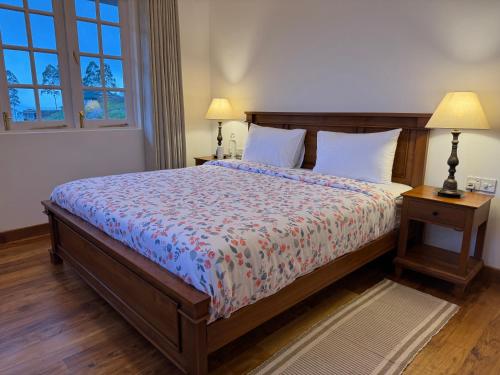 a bedroom with a large bed and two night stands at The Mountain Links, Upcot, Nuwara Eliya in Maskeliya