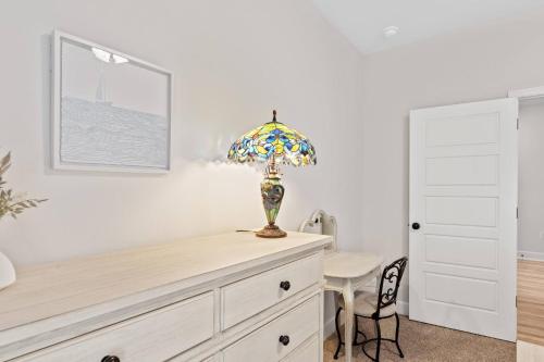 a room with a dresser with a lamp on it at Spacious 4BR Home Near Midtown & FSU in Saint Peter