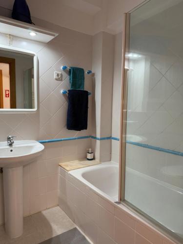 Un baño con ducha, bañera y lavabo. en Sesimbra Village T1, en Sesimbra