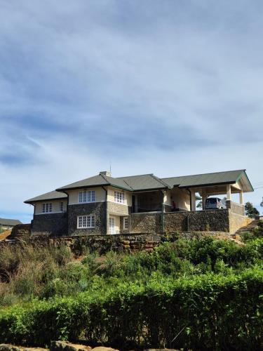 a large house on a hill withgrass at The Mountain Links, Upcot, Nuwara Eliya in Maskeliya