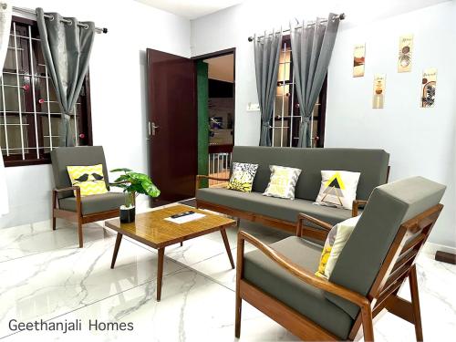a living room with a couch and chairs and a table at Geethanjali Homes in Kanyakumari