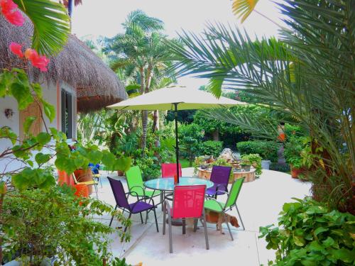 a patio with a table and chairs and an umbrella at Casa Gatos in Akumal