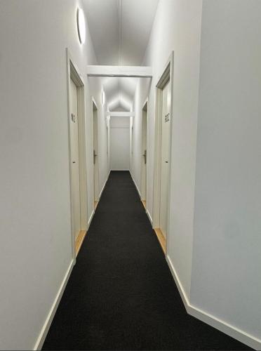 a hallway with white walls and a long hallway with doors at Vognstrupgaard in Silkeborg