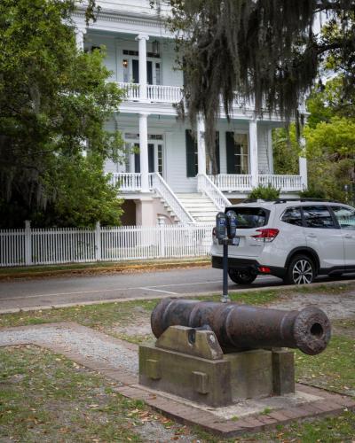 a cannon and a parking meter in front of a house at City Loft Hotel in Beaufort
