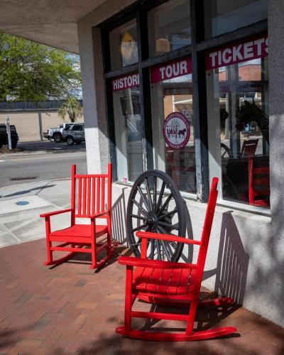 two red chairs sitting in front of a store at City Loft Hotel in Beaufort