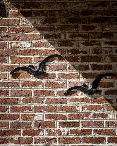 a shadow of a brick wall with a metal bracket at City Loft Hotel in Beaufort